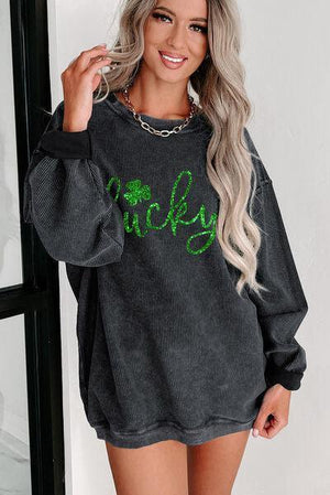 a woman wearing a black sweater with green lettering on it