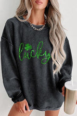 a woman wearing a grey sweater with green lettering