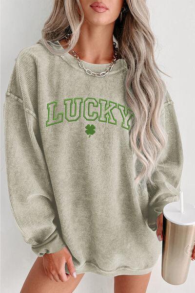 a woman wearing a green sweater with lucky on it