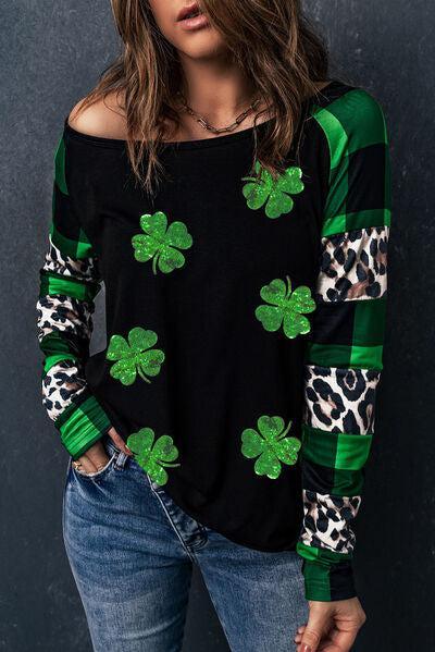 a woman wearing a black and green top with shamrocks on it