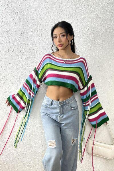 a woman wearing ripped jeans and a striped sweater