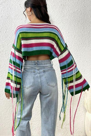 a woman wearing a colorful striped sweater and jeans