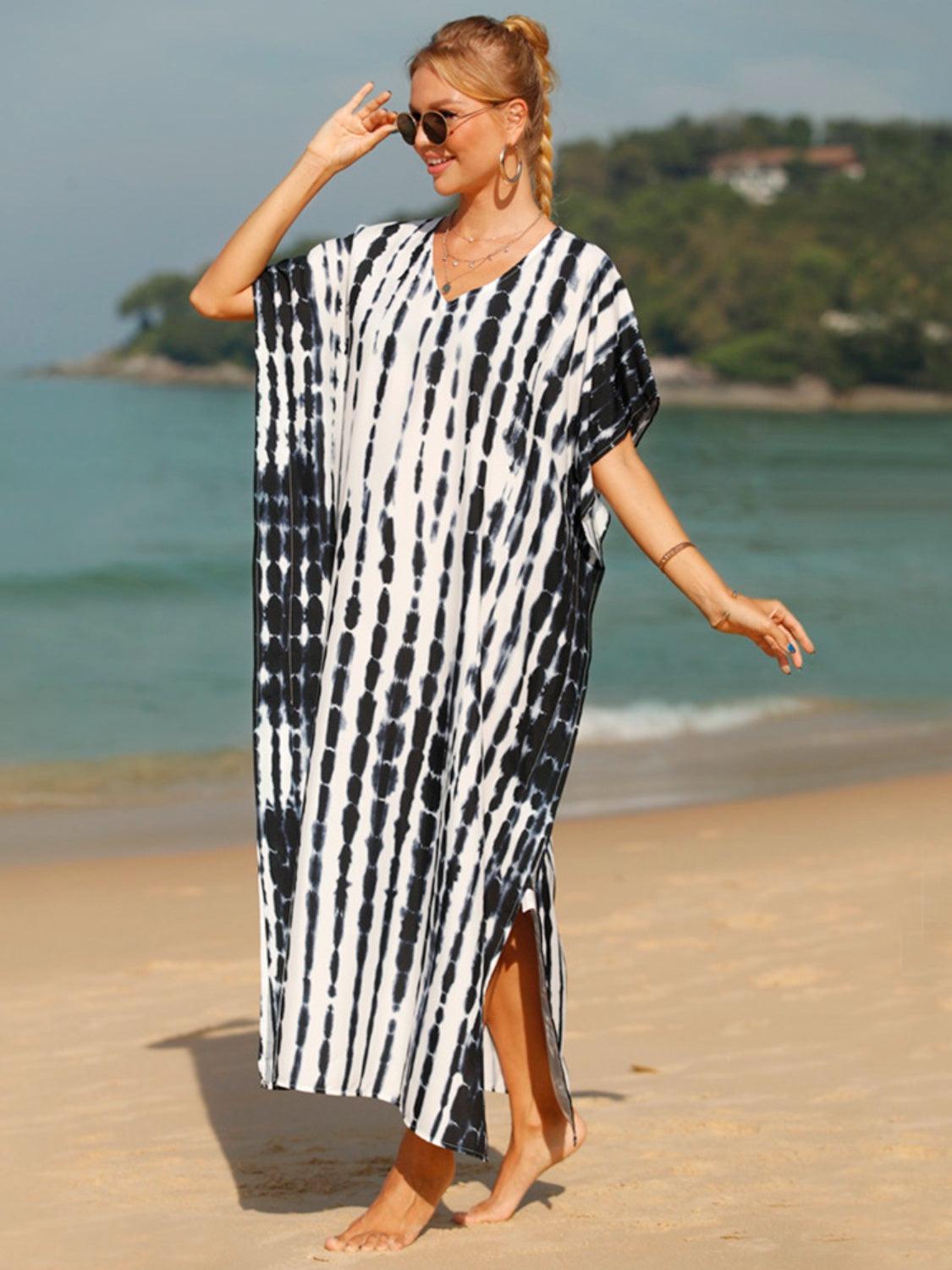 a woman in a black and white dress on the beach