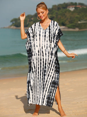 a woman in a black and white dress on the beach