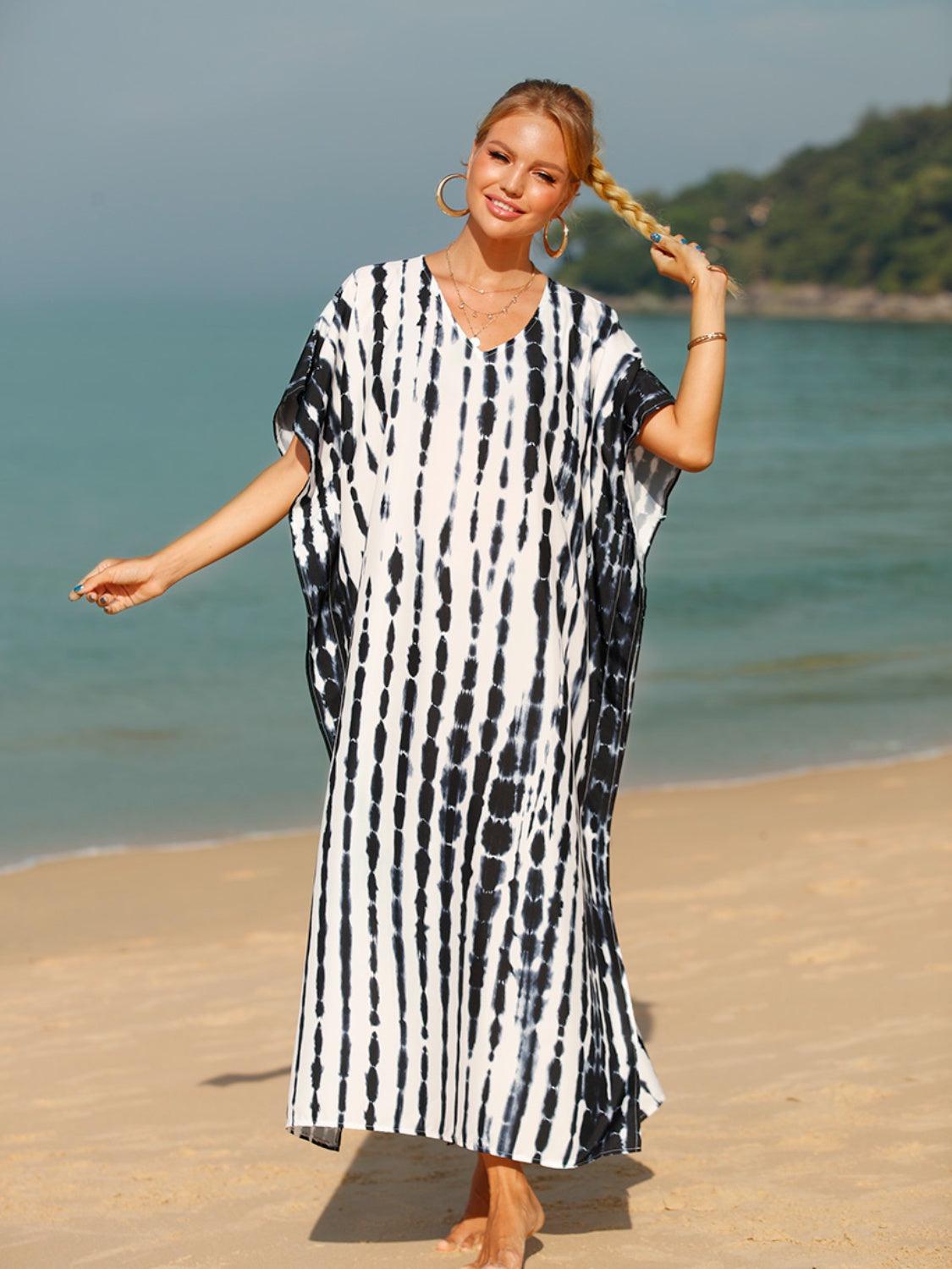 a woman in a black and white dress on the beach