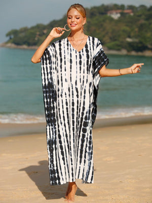 a woman standing on a beach wearing a black and white dress