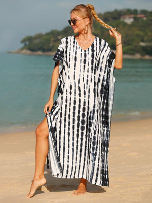 a woman in a black and white dress on the beach