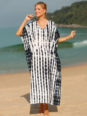 a woman standing on a beach wearing a black and white dress