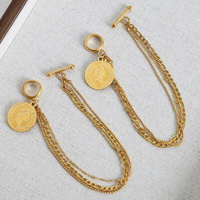 a pair of gold chain earrings with a coin hanging from it