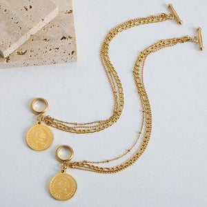 a gold necklace with two charms on it