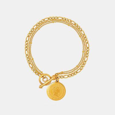 a gold bracelet with a coin on it