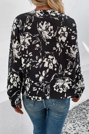 a woman wearing a black and white floral blouse