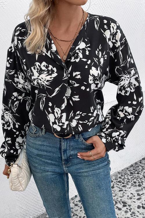 a woman wearing a black and white floral blouse