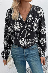 a woman wearing a black and white floral blouse