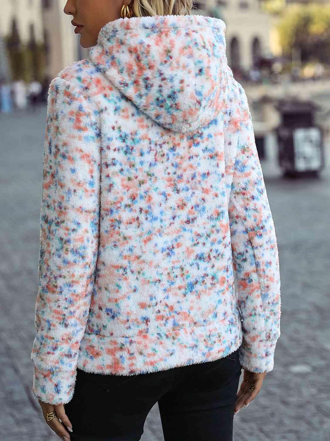 a woman wearing a colorful jacket and black pants