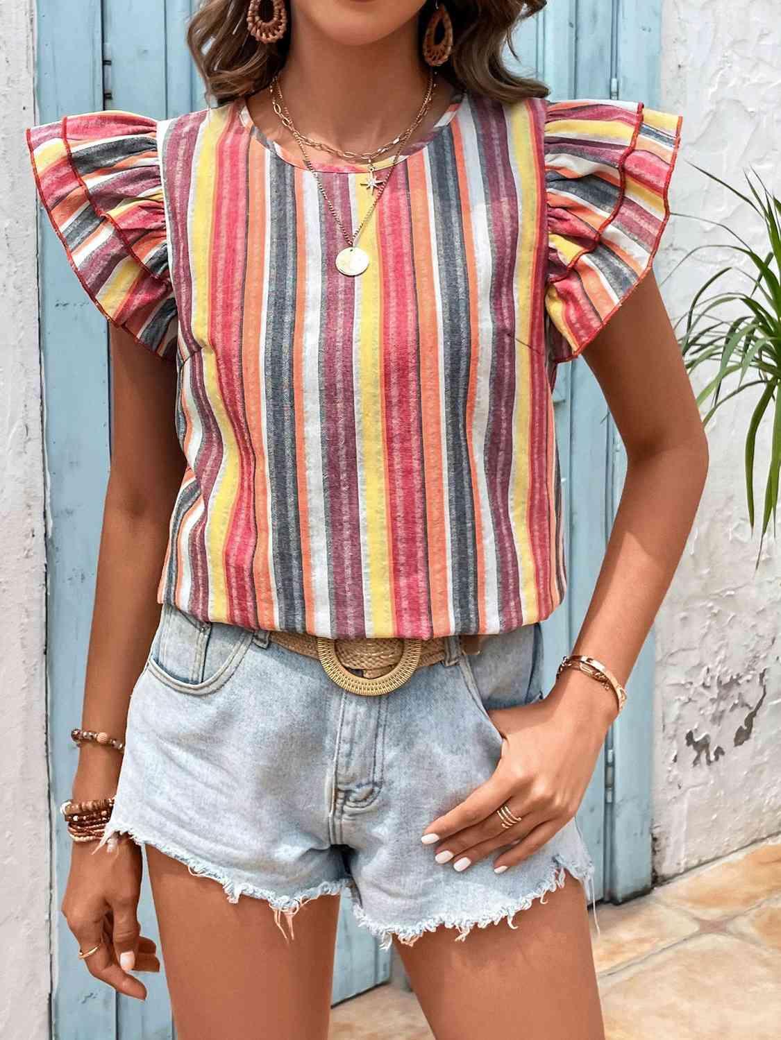 a woman wearing a striped top and denim shorts