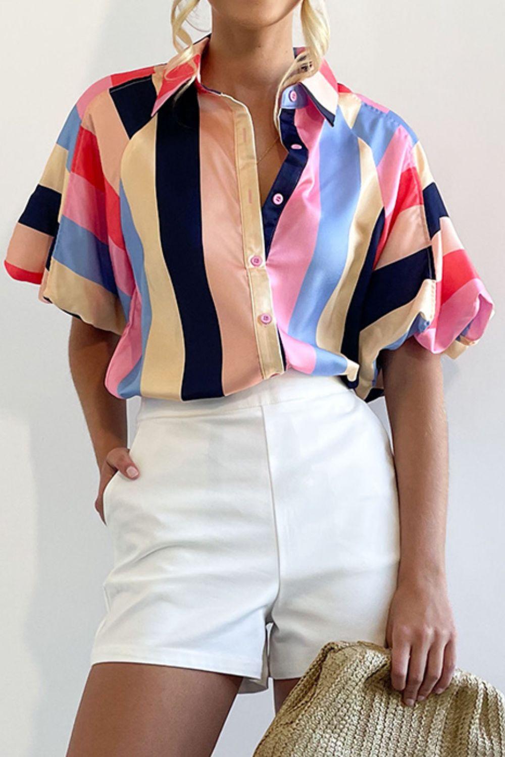 a woman in a colorful shirt and white shorts