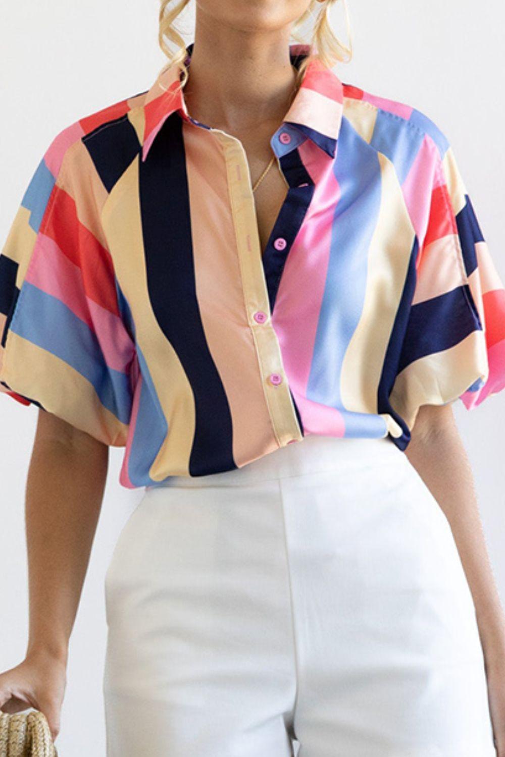 a woman wearing a colorful shirt and white pants