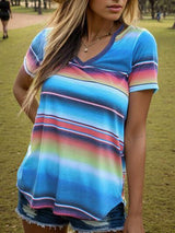 a beautiful young woman standing in a park wearing a hat