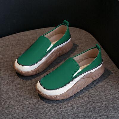 a pair of green shoes sitting on top of a couch