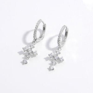 a pair of diamond earrings on a white background