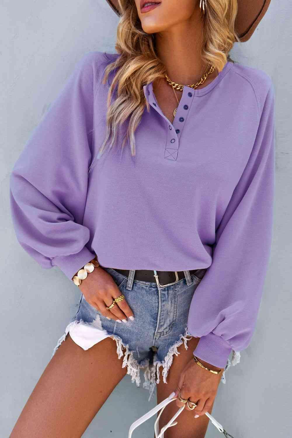 a woman wearing a purple shirt and denim shorts