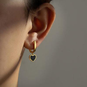 a close up of a person wearing a pair of earrings