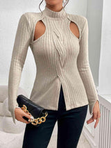 a woman wearing a beige sweater and black pants