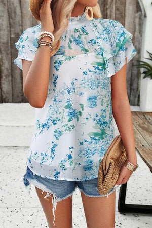 a woman wearing a straw hat and blue floral top