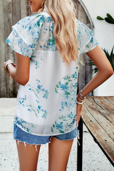 a woman wearing a blue and white floral blouse