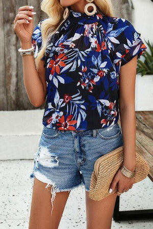 a woman in a floral top smoking a cigarette