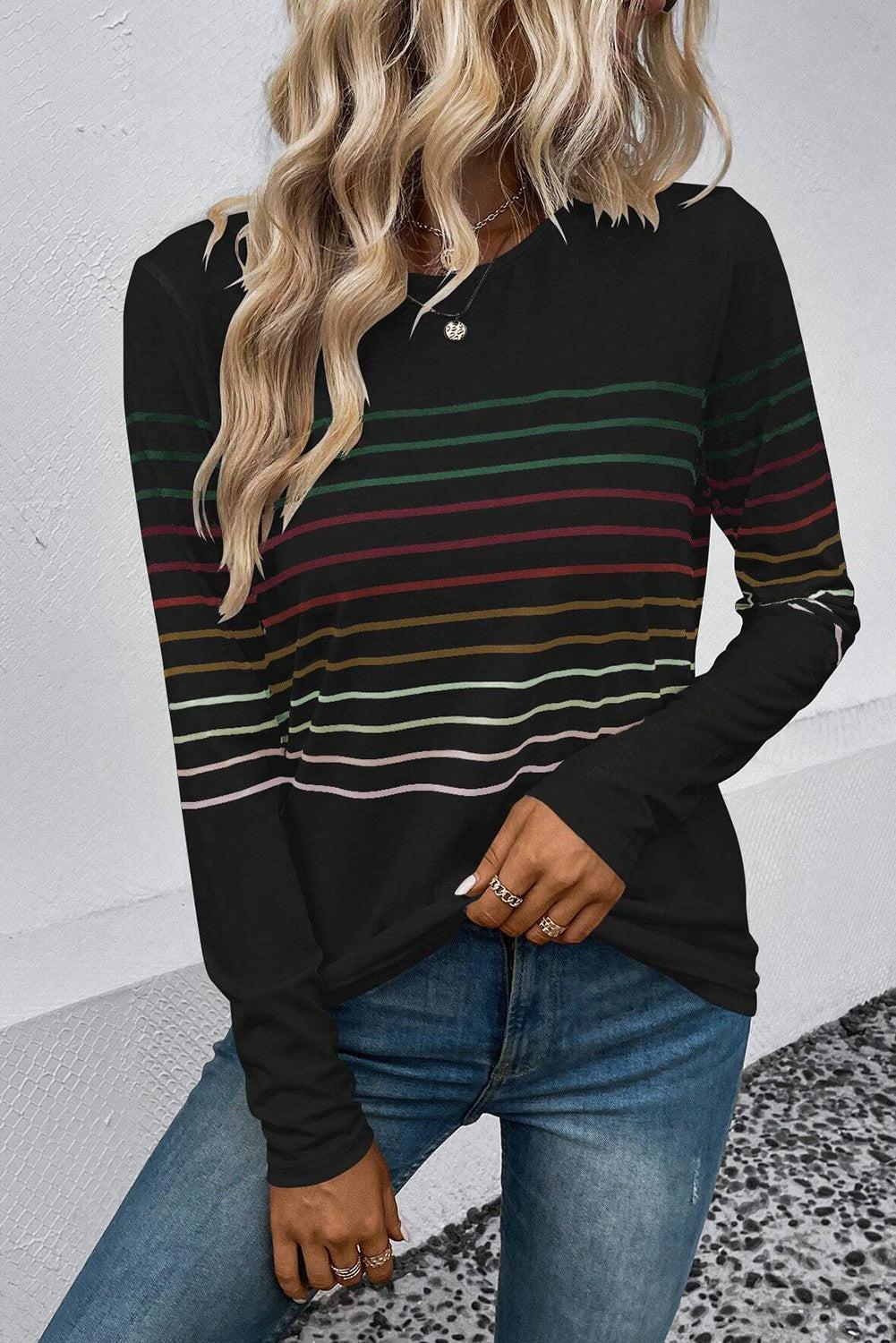 a woman with blonde hair wearing a black striped top