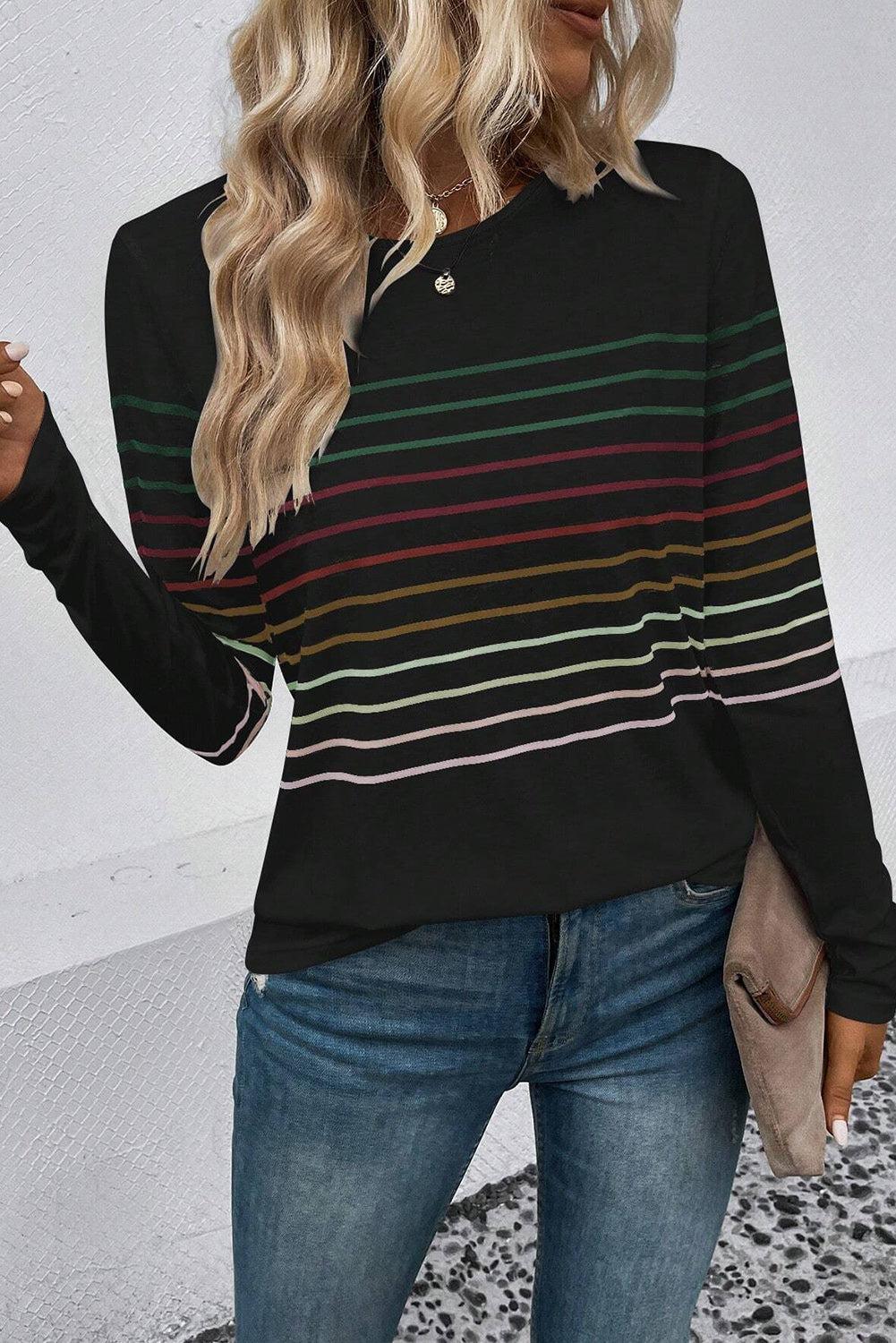 a woman with blonde hair wearing a black striped sweater