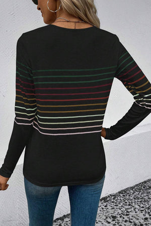 a woman wearing a black striped sweater and jeans
