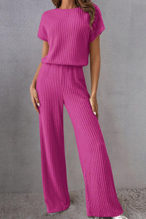 a woman in a pink top and wide legged pants