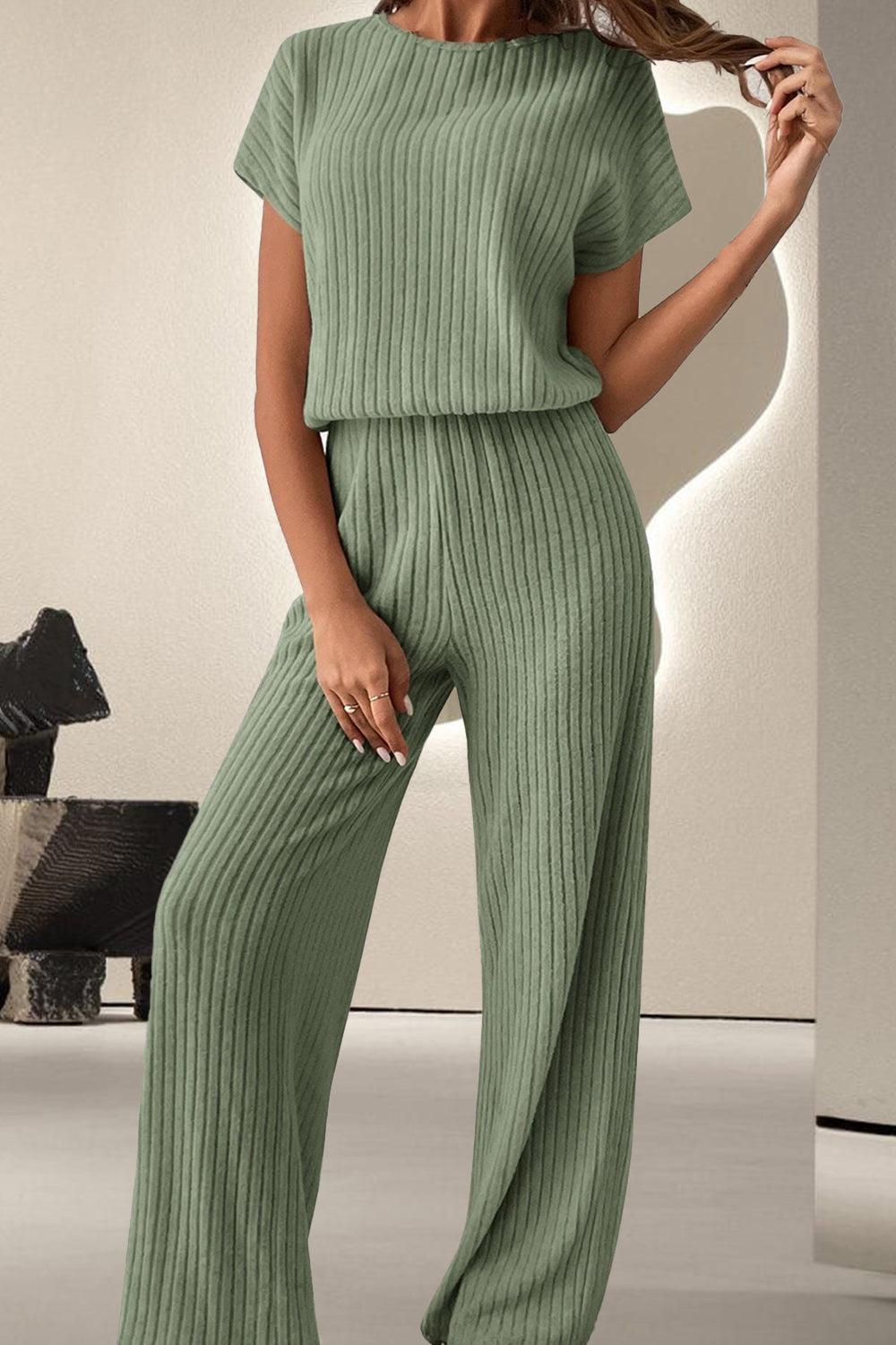 a woman in a green jumpsuit posing for a picture