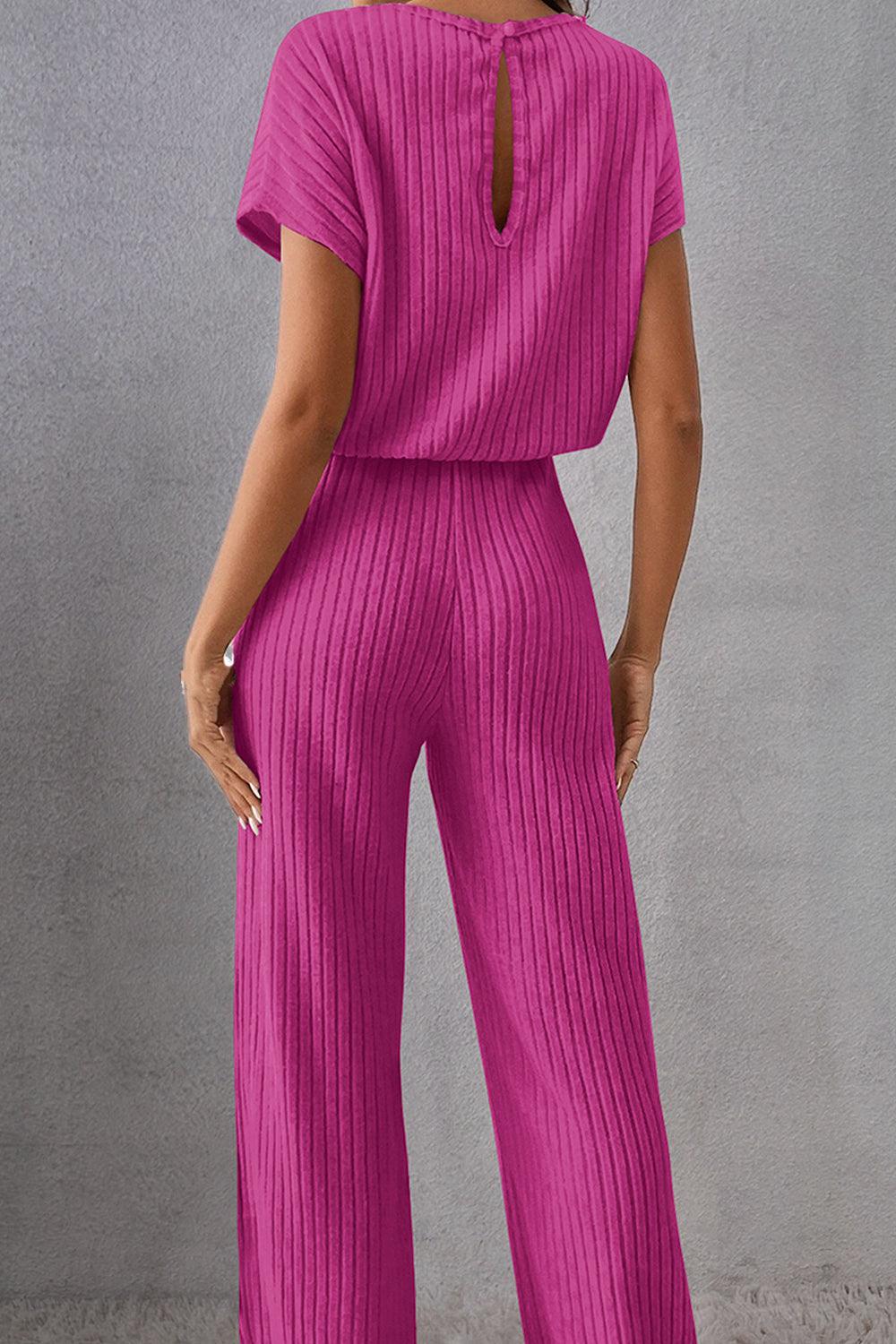 a woman in a pink jumpsuit with a back cut out