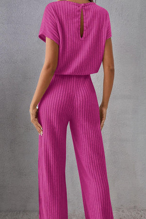 a woman in a pink jumpsuit with a back cut out