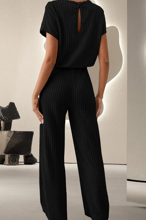 a woman wearing a black jumpsuit with a back cut out