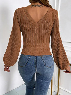 a woman wearing a brown sweater and jeans