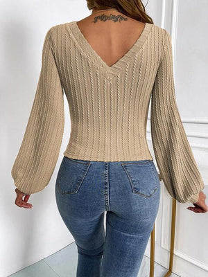 a woman in jeans and a sweater is standing in a room