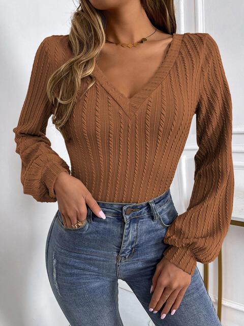 a woman wearing a brown sweater and jeans