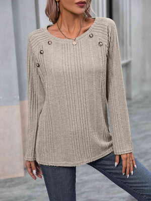 a woman wearing a tan sweater and jeans