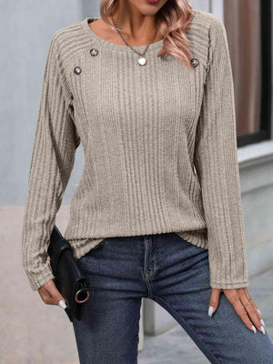 a woman wearing a tan sweater and jeans