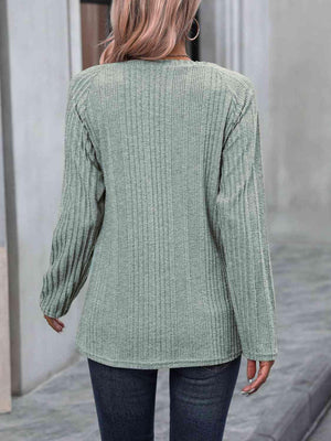 a woman wearing a green sweater and jeans