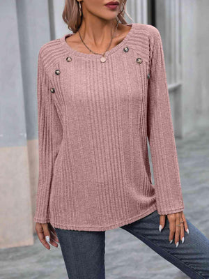 a woman wearing a pink sweater and jeans