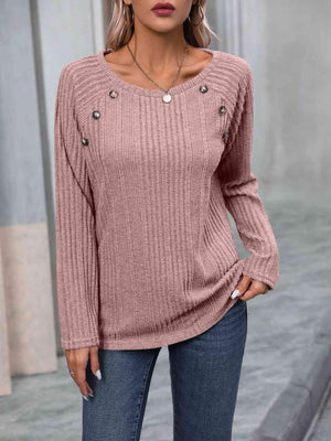 a woman wearing a pink sweater and jeans