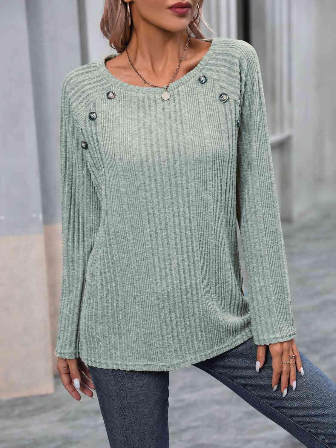 a woman wearing a green sweater and jeans