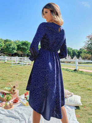 a woman in a blue dress standing in front of a picnic table