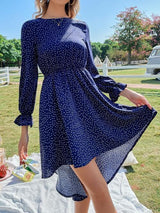 a woman standing on a blanket in a blue dress